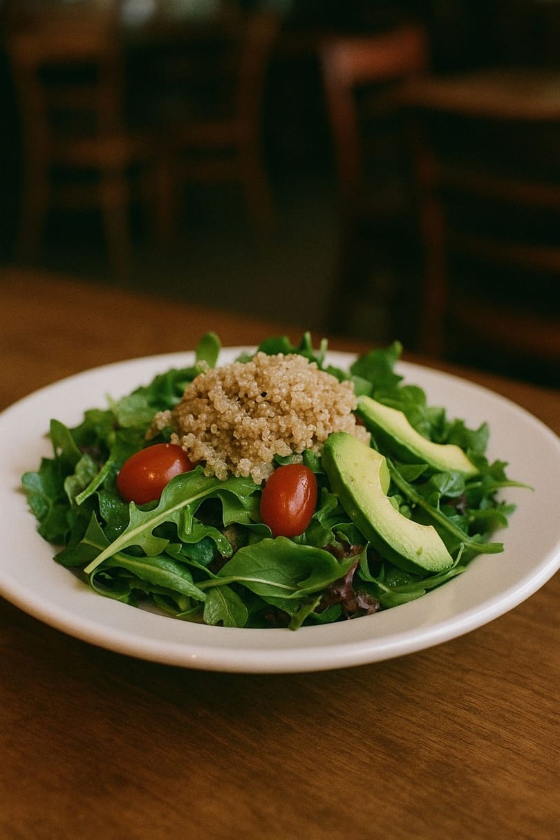Fresh Desert Sky Café salad with quinoa, cherry tomatoes, and avocado slices on mixed greens.
